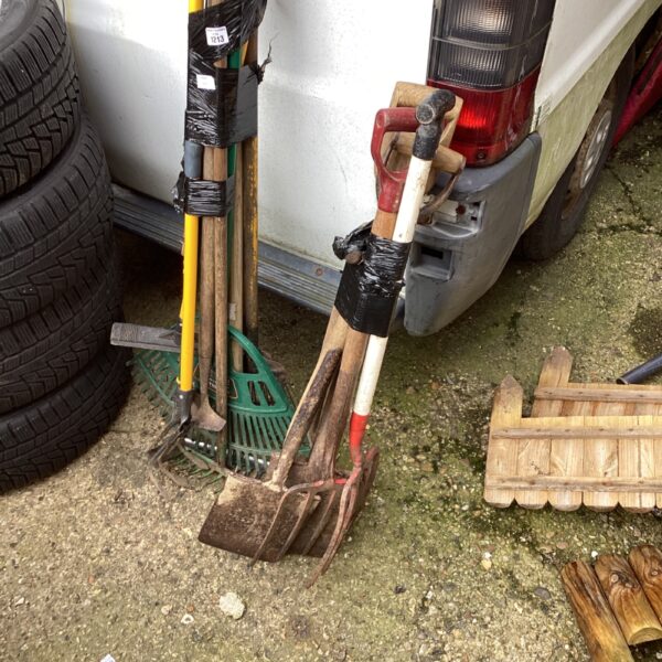 Bundle of garden tools including a rake and shovel for outdoor use.
