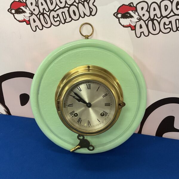 Vintage German brass bulkhead clock with white dial.