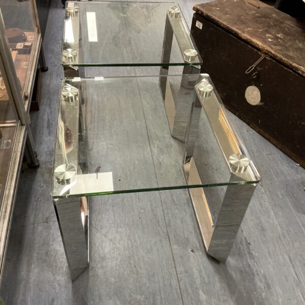 Two glass coffee tables with chrome legs, mid century modern style.