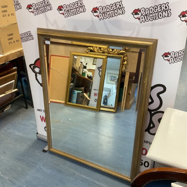 Large gold framed overmantle mirror with ornate detailing.