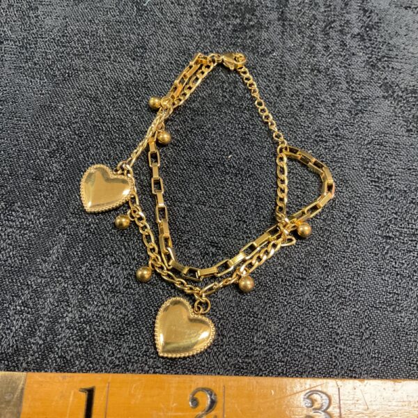 Delicate gold heart bracelet with double heart pendants.