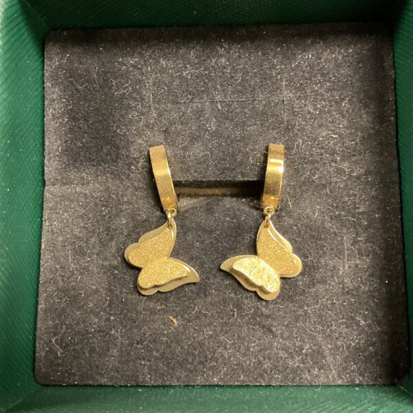 Close-up of elegant gold plated butterfly earrings.