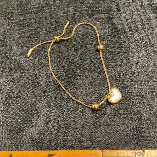 Elegant gold plated heart rope bracelet with mother of pearl pendant.