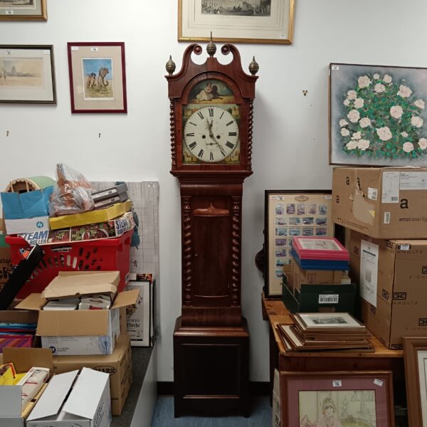 Antique grandfather clock by David Lumsden Anstruther in a cluttered room.