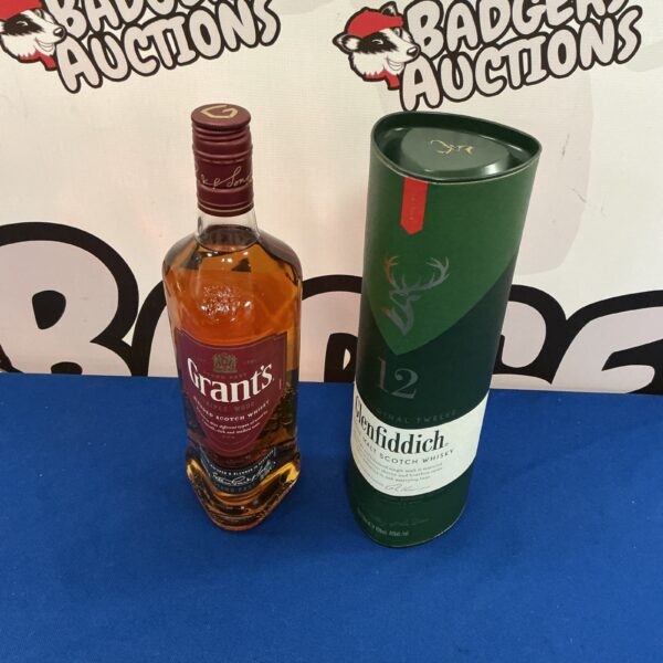 Two bottles of Scotch whiskey, Grant's and Glenfiddich, presented for auction.