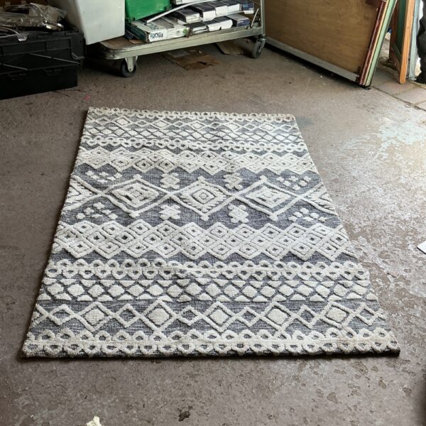 Grey and off-white geometric patterned area rug for home decor.