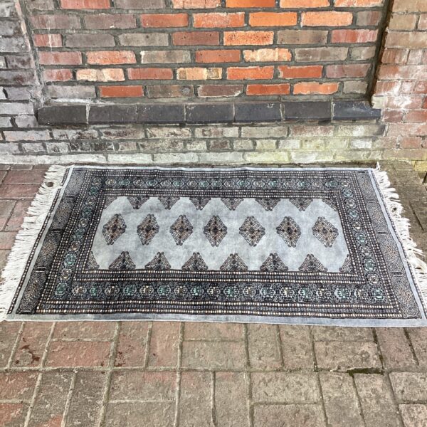 Grey hand-made Persian rug with tassels, vintage style.