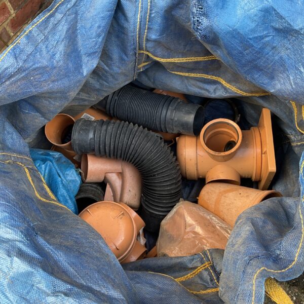 Assorted PVC gutter fittings in a blue sack.