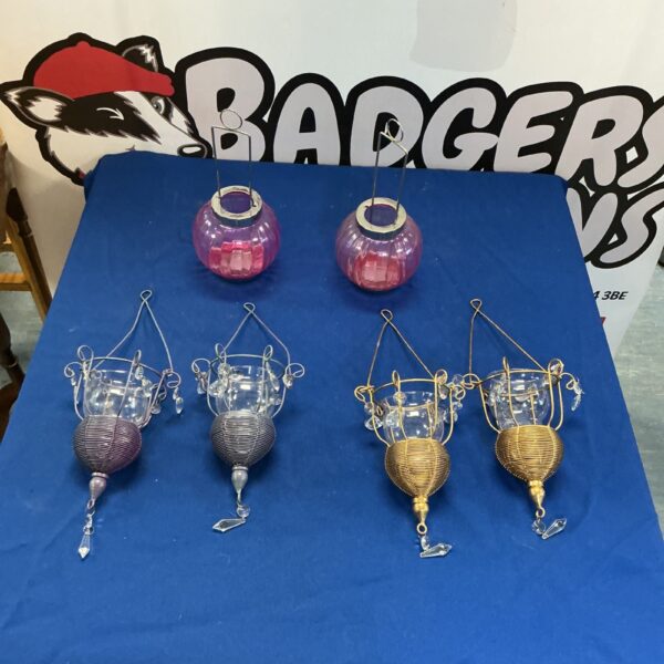 Decorative hanging tealight holders with glass and metal detailing.