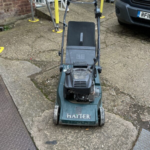 Vintage Hayter petrol lawnmower in a garden setting.