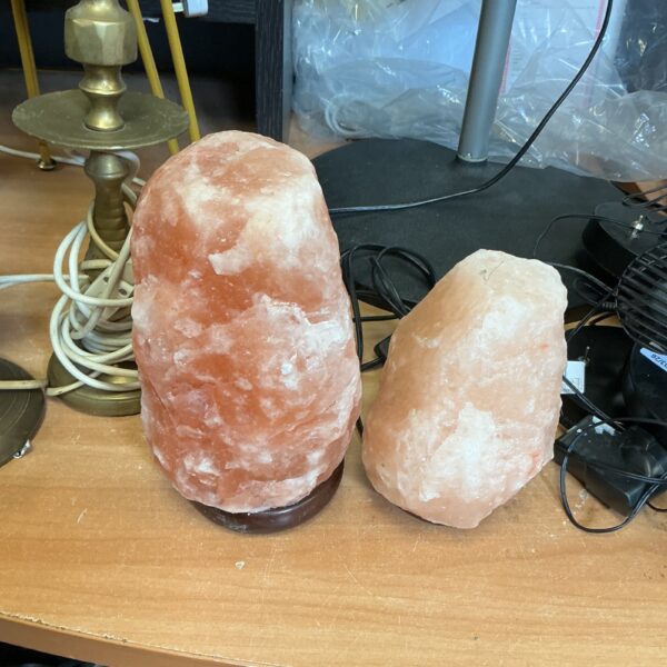 Pair of Himalayan salt lamps on display, warm ambient lighting.