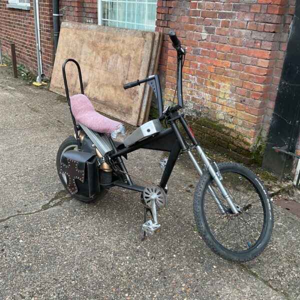 Side view of a custom homemade chopper bike with electric assist.