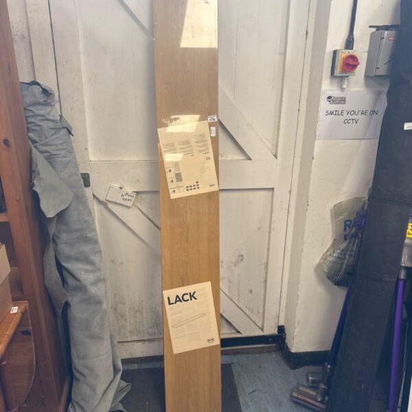 Stacked IKEA Lack shelves leaning against a wall.