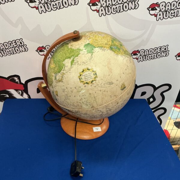 Vintage illuminated world globe on wooden stand, detailed map.