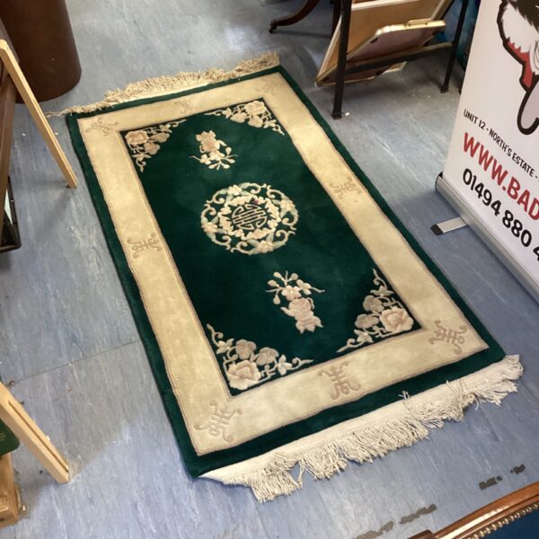 Green oriental floral patterned rug approximately 5ft x 2.5ft