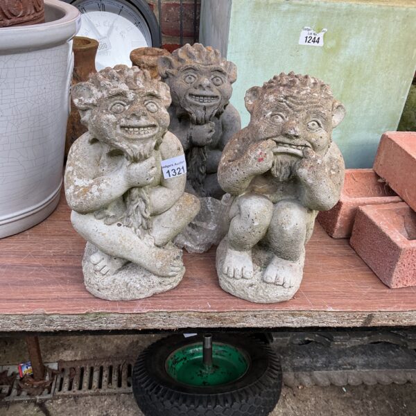 Lot of three concrete imp garden ornaments for whimsical garden decor.