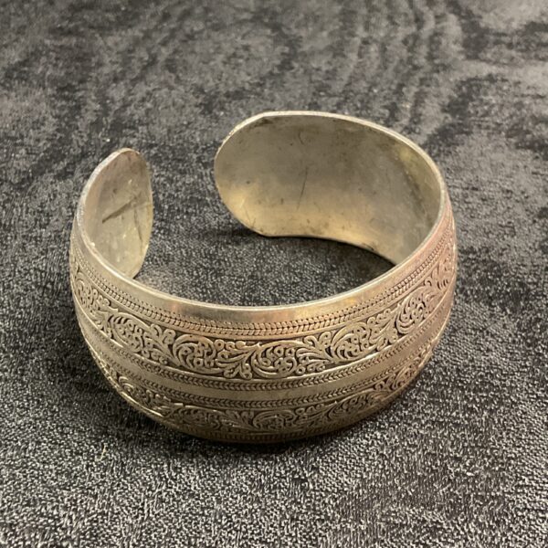 Intricate Indian silver cuff bracelet with floral designs.