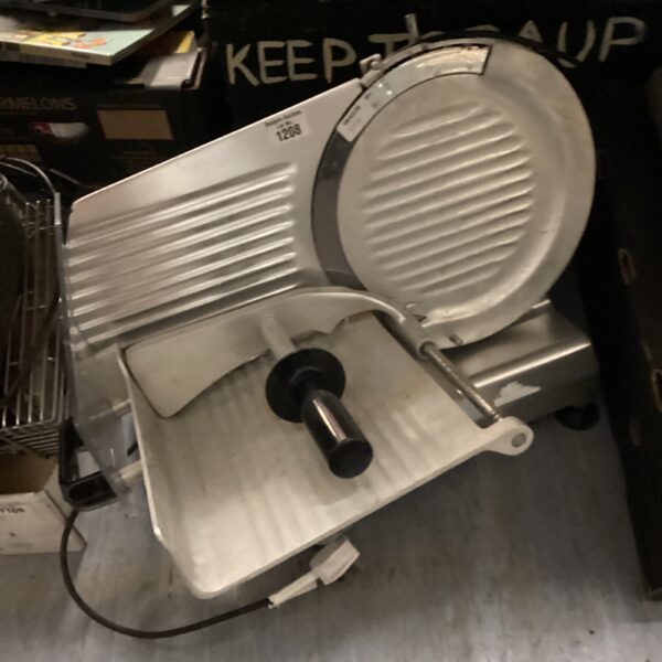 Front view of a large industrial meat slicer.