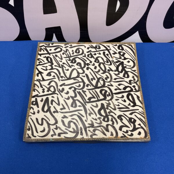 Intricate Islamic hand made tile with brass surround.