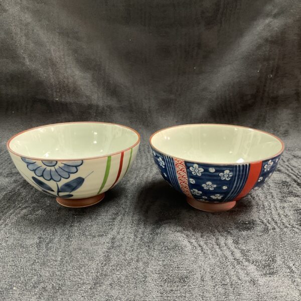 Blue floral hand-painted Japanese rice bowl on textured surface.