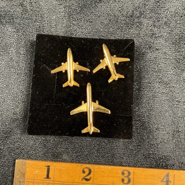 Three vintage jet airliner pin badges, aviation collectible.