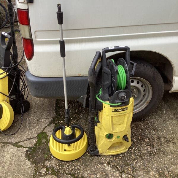 Karcher K4 pressure washer with attachments for garden cleaning.