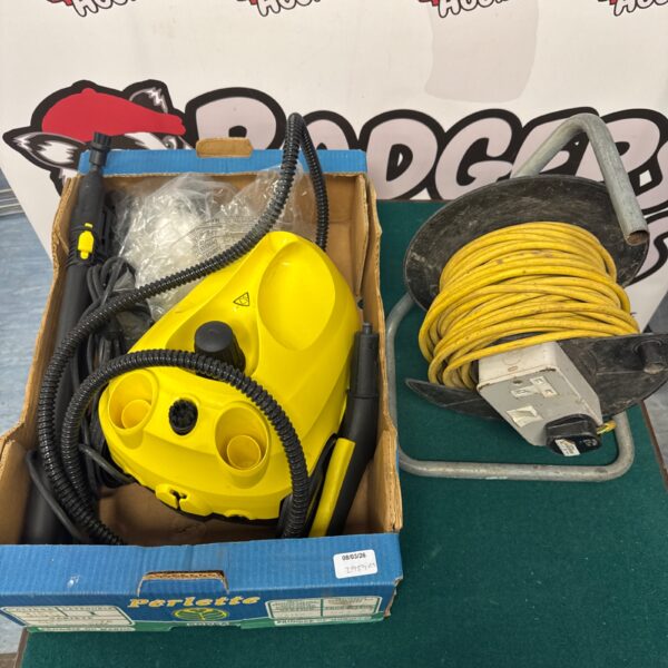 Yellow Karcher pressure washer with black extension reel attached.