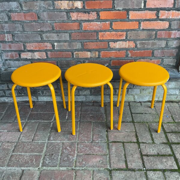 Group of three vintage yellow Kinnarps stools.