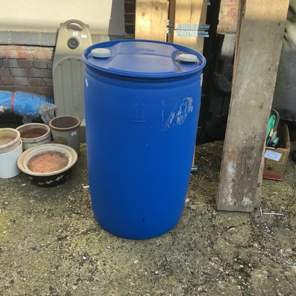 Large blue plastic water barrel for garden storage and rainwater harvesting.
