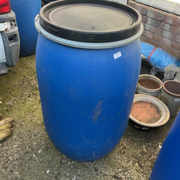 Blue large water butt for rainwater harvesting in a garden setting.