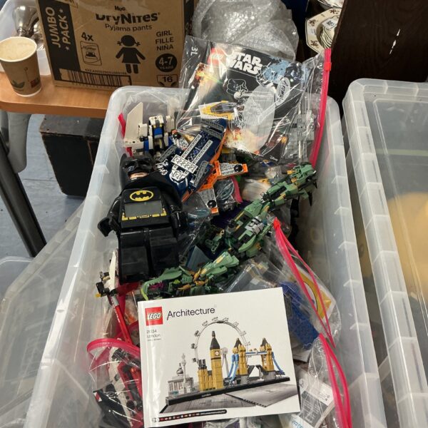 Mixed Lego sets including Star Wars elements in a storage box.