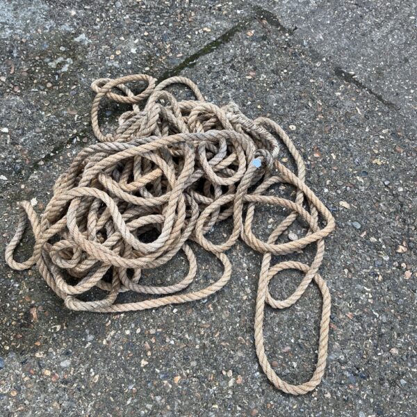 Coiled length of thick, natural manila rope for nautical use.