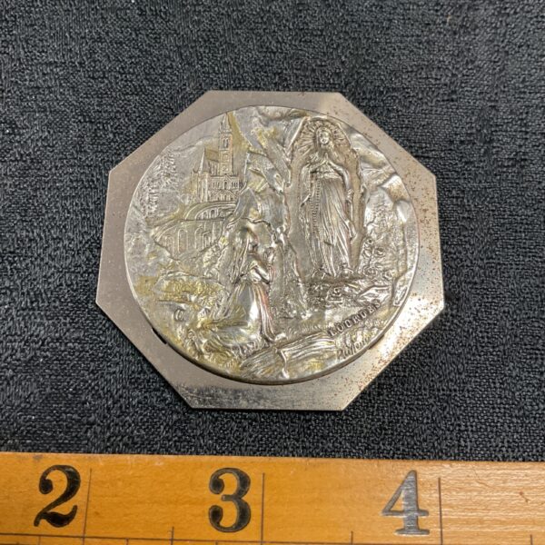 Vintage Lourdes medal depicting the grotto, a religious devotional item.