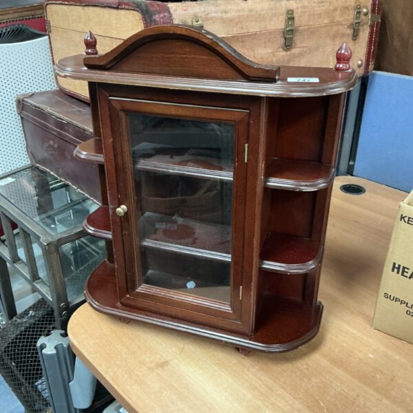 Vintage mahogany display cabinet for collectibles and small items.