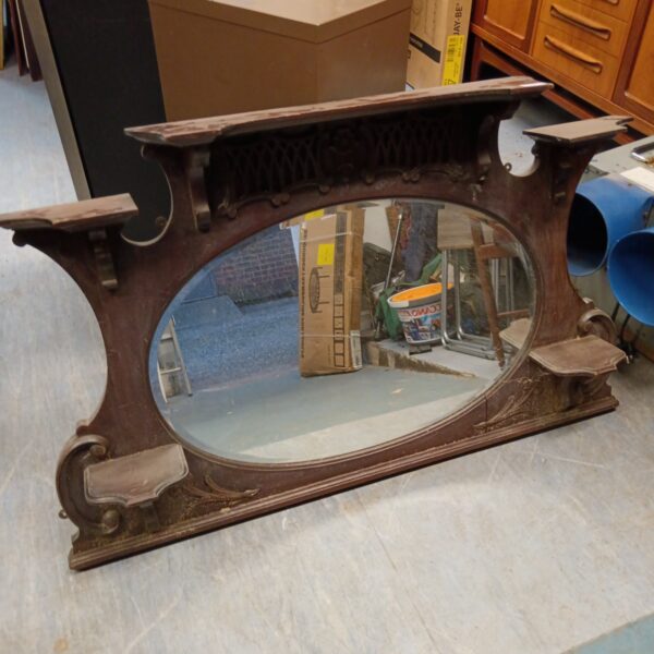 Antique mahogany overmantle mirror with intricate carvings.