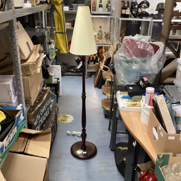 Vintage mahogany standard lamp with cream shade in a room setting.