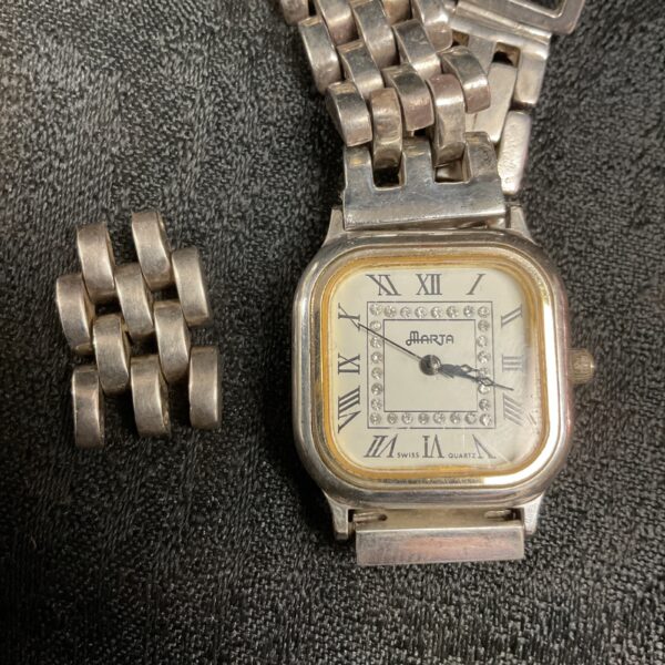 Close-up of the silver dial of a vintage Marta wristwatch.