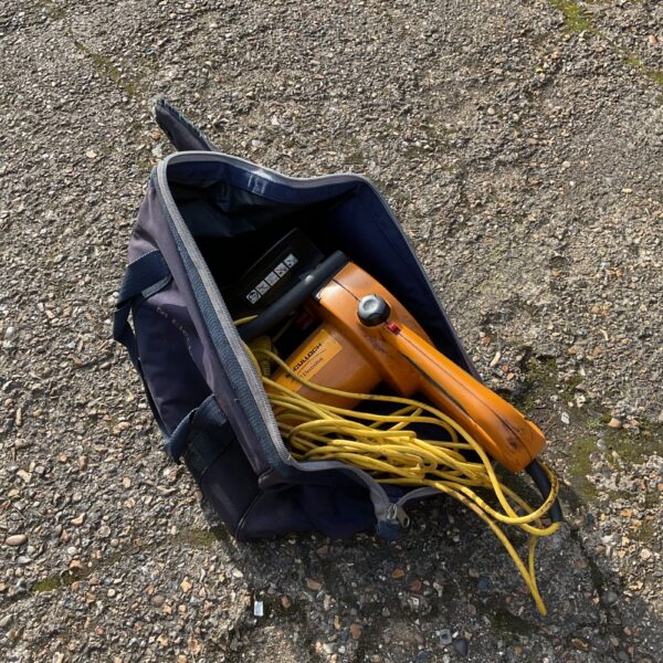 McCulloch electric chainsaw in its original carry case, vintage garden tool.