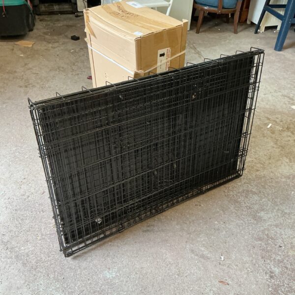 Large metal animal transport crate for secure pet travel.