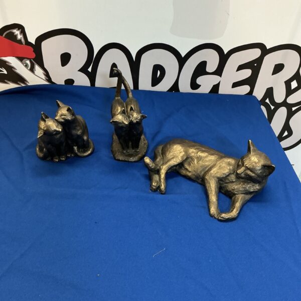 Three vintage metal cat ornaments displayed together.