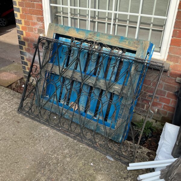 Pair of decorative metal garden gates with wrought iron detailing.