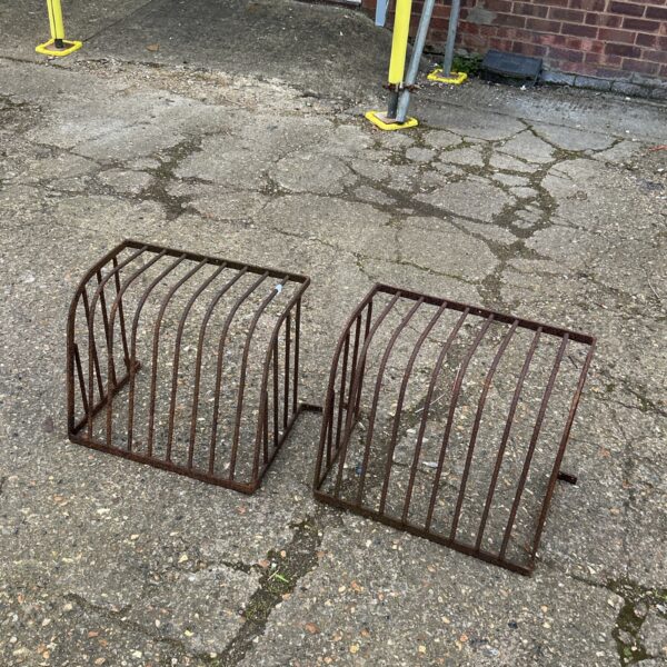 Pair of vintage metal hay mangers for livestock feeding.