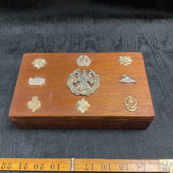 Vintage military badge cigarette box with badges on lid.