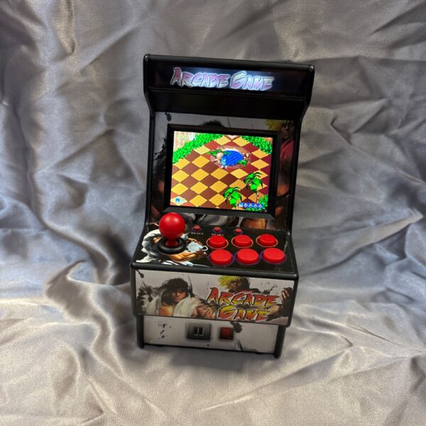 Close-up of a mini arcade game machine with a colourful screen.