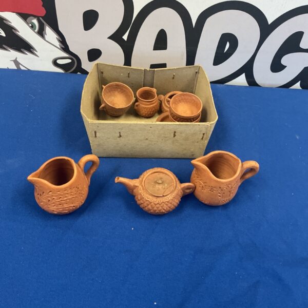 Vintage miniature pottery collection with terracotta teapot and cups.