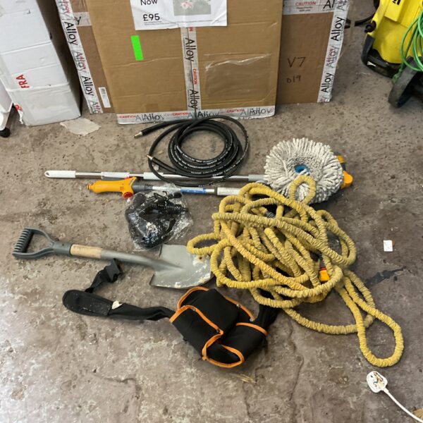 Mixed tool lot including a tool belt and garden hose for DIY projects.