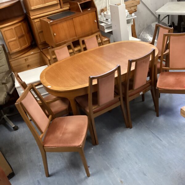 Vintage Nathan extending dining table with eight chairs.