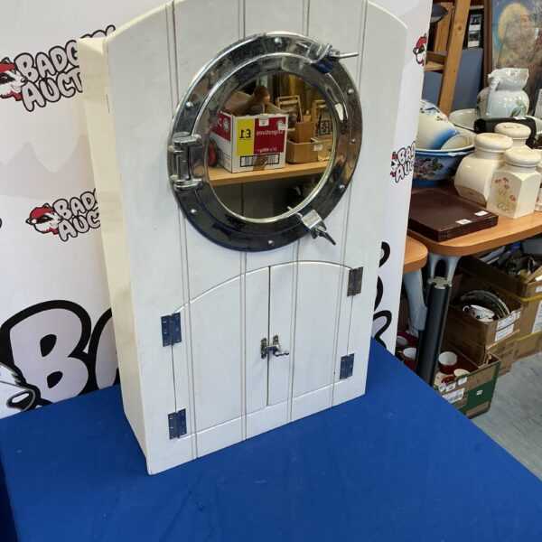 Vintage nautical bathroom cabinet with porthole design.