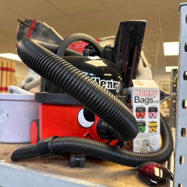 Red Numatic Henry Hoover with spare bags for domestic cleaning.