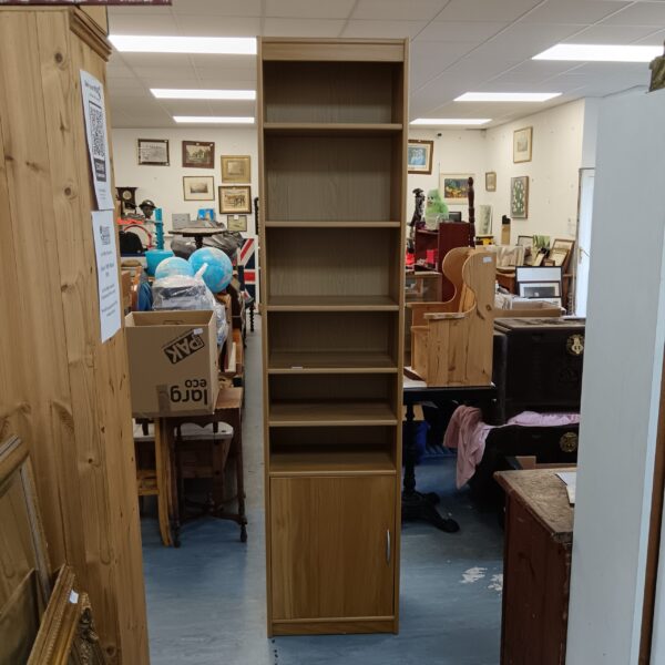 Tall oak bookcase with cabinet for books and display items.